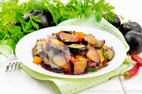 Image of Eggplant with plums in plate on board