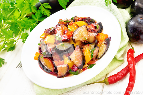 Image of Eggplant with plums in plate on napkin