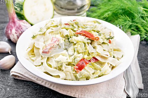 Image of Fettuccine with zucchini and hot peppers in plate on board