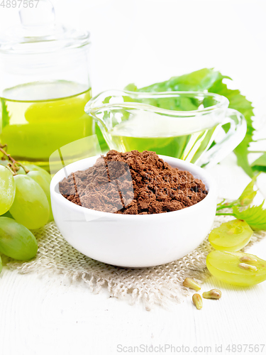 Image of Flour grape seed in bowl on white wooden board