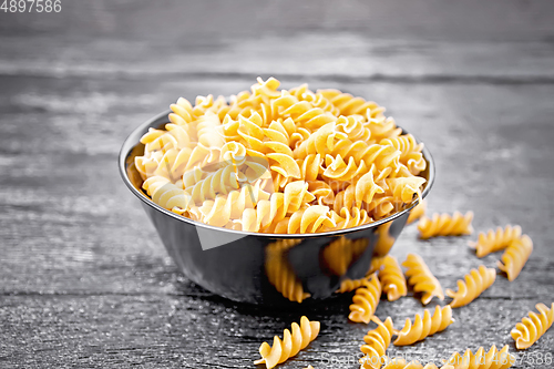 Image of Fusilli whole grain in bowl on wooden board