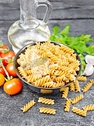 Image of Fusilli whole grain in bowl with vegetables on black board