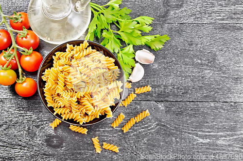 Image of Fusilli whole grain in bowl with vegetables on dark board top