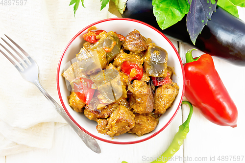 Image of Meat with eggplant and pepper in bowl on light board top
