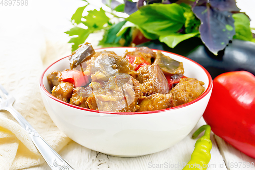 Image of Meat with eggplant and pepper in bowl on light board