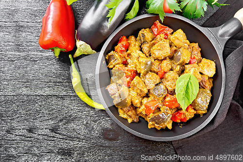 Image of Meat with eggplant and pepper in pan on board top