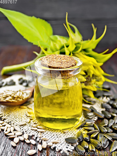 Image of Oil sunflower in jar with flower on dark board