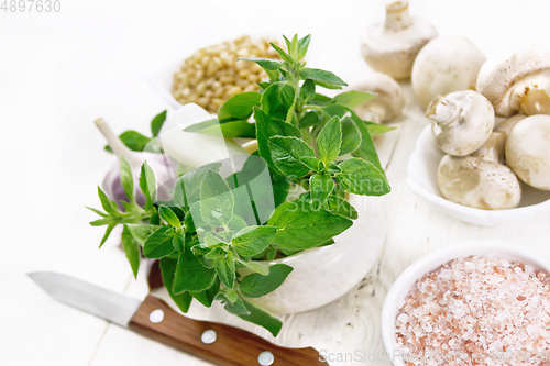 Image of Oregano fresh in mortar on wooden table