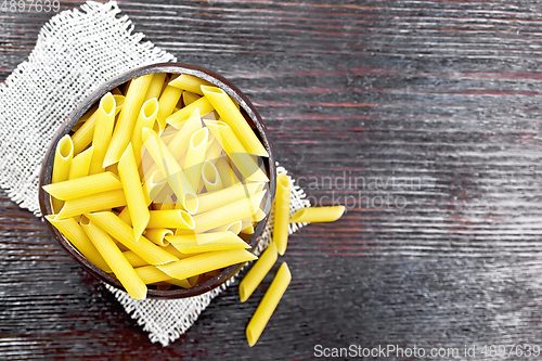 Image of Penne in bowl of coconut on board top