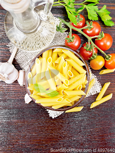 Image of Penne in bowl of coconut with vegetables on board top