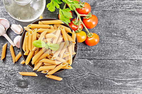 Image of Penne whole grain in bowl with vegetables on board top
