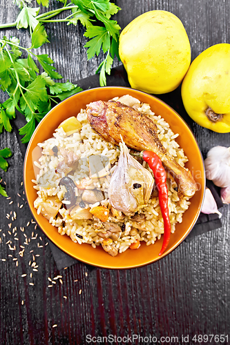 Image of Pilaf with duck and quince in plate on black board top