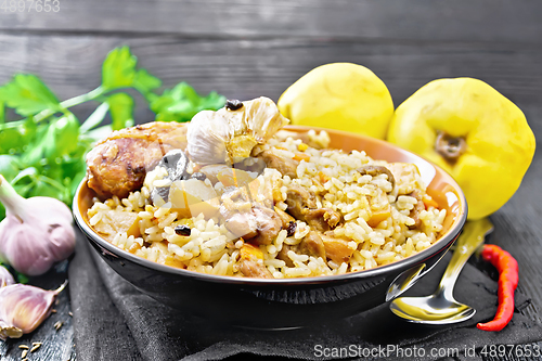 Image of Pilaf with duck and quince in plate on dark board