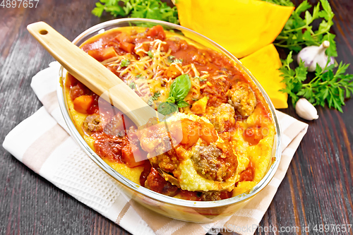 Image of Porridge corn with meat and spoon in roaster on napkin