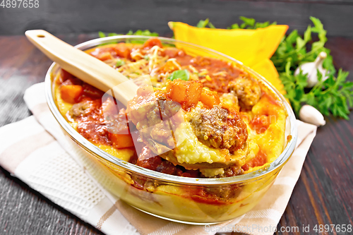 Image of Porridge corn with meat and spoon in roaster on towel