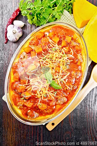 Image of Porridge corn with meat and vegetables in roaster on dark board 