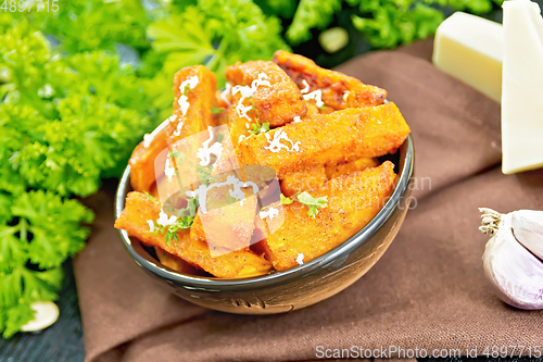 Image of Pumpkin fried with spices in bowl on dark board