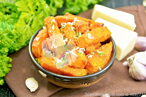 Image of Pumpkin fried with spices in bowl on wooden board