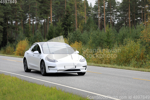 Image of White Tesla Model 3 Electric Car on Rural Highway