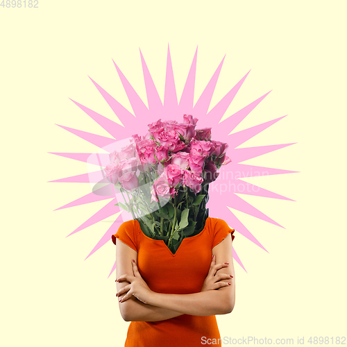 Image of Contemporary art collage. A woman\'s body with bunch of beautiful pink roses as a head on yellow studio background.