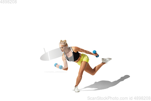 Image of Beautiful young female athlete practicing on white studio background with shadow