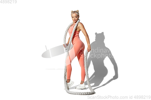 Image of Beautiful young female athlete practicing on white studio background with shadow