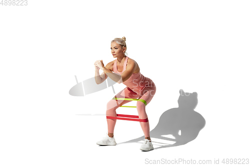 Image of Beautiful young female athlete practicing on white studio background with shadow