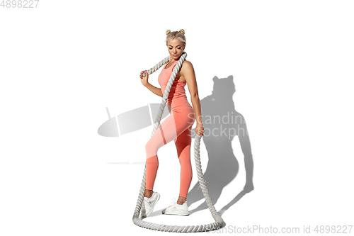 Image of Beautiful young female athlete practicing on white studio background with shadow