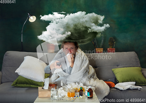 Image of Ill young girl with fever and cold looks suffering at home