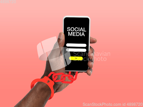 Image of Hand using smartphone, device on top view. Addicted, wired with chain to social media on the screen