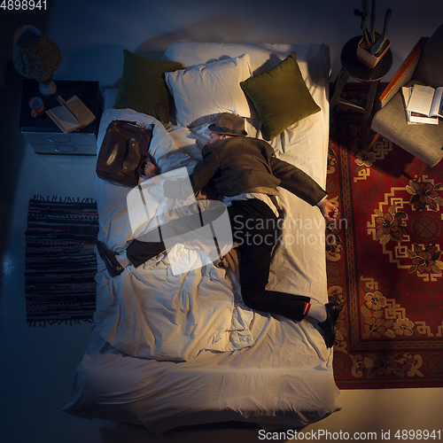 Image of Portrait of a businessman, accountant sleeping in the bed at home