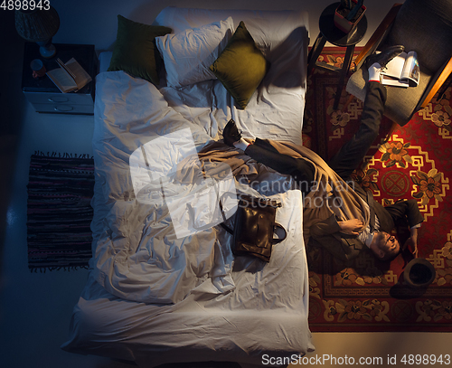 Image of Portrait of a businessman, accountant sleeping in the bed at home