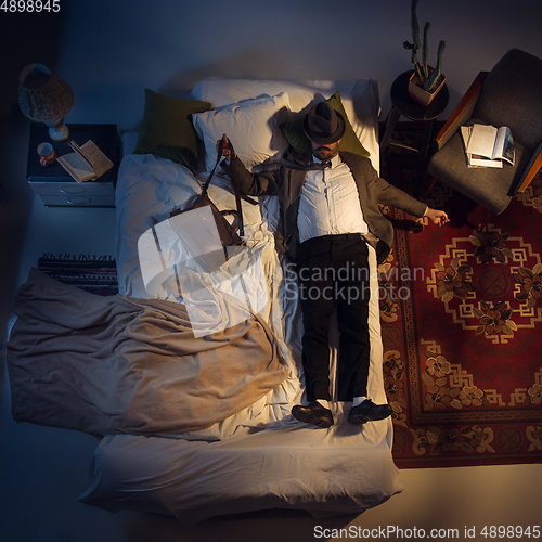 Image of Portrait of a businessman, accountant sleeping in the bed at home