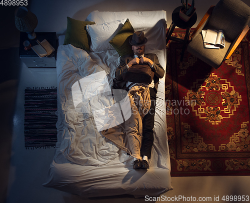 Image of Portrait of a businessman, accountant sleeping in the bed at home