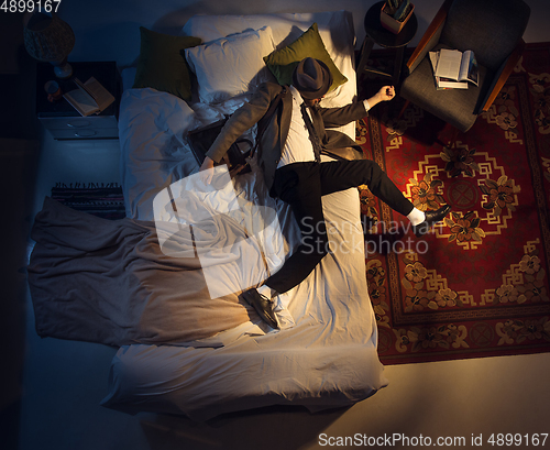 Image of Portrait of a businessman, accountant sleeping in the bed at home