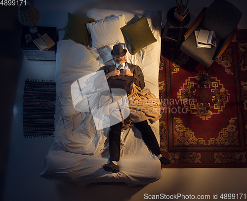 Image of Portrait of a businessman, accountant sleeping in the bed at home