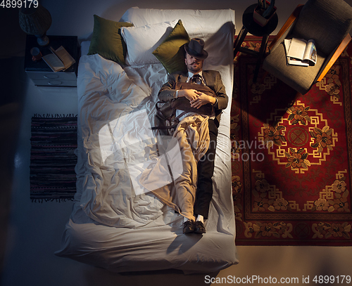 Image of Portrait of a businessman, accountant sleeping in the bed at home