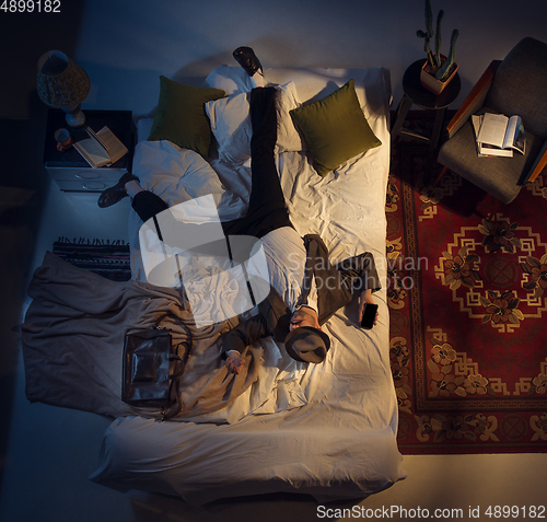 Image of Portrait of a businessman, accountant sleeping in the bed at home