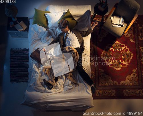 Image of Portrait of a businessman, accountant sleeping in the bed at home
