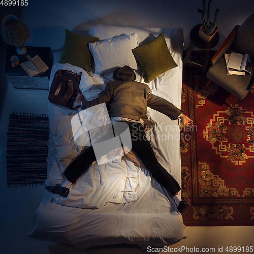 Image of Portrait of a businessman, accountant sleeping in the bed at home