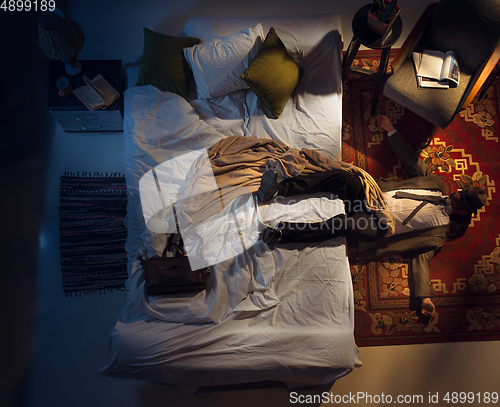 Image of Portrait of a businessman, accountant sleeping in the bed at home