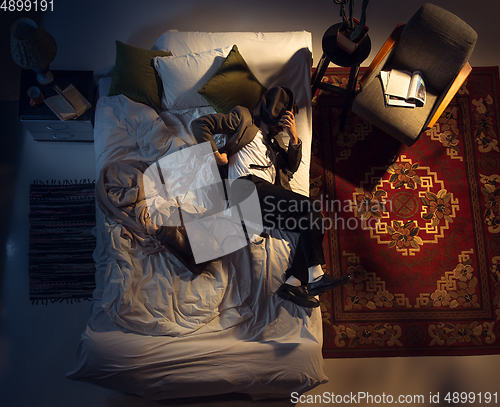 Image of Portrait of a businessman, accountant sleeping in the bed at home