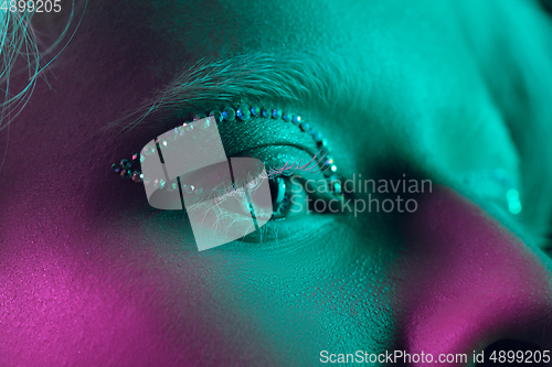 Image of Portrait of beautiful albino girl isolated on dark studio background in neon light