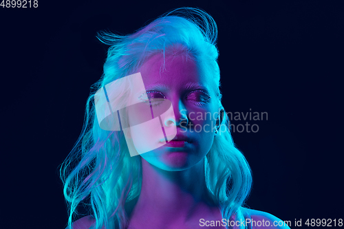 Image of Portrait of beautiful albino girl isolated on dark studio background in neon light