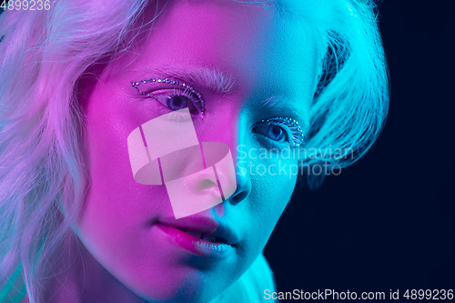 Image of Portrait of beautiful albino girl isolated on dark studio background in neon light