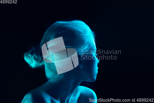 Image of Portrait of beautiful albino girl isolated on dark studio background in neon light