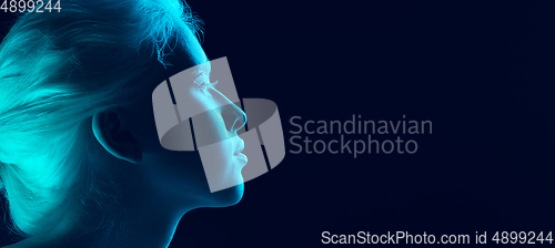 Image of Portrait of beautiful albino girl isolated on dark studio background in neon light