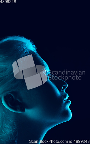 Image of Portrait of beautiful albino girl isolated on dark studio background in neon light