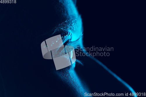 Image of Portrait of beautiful albino girl isolated on dark studio background in neon light