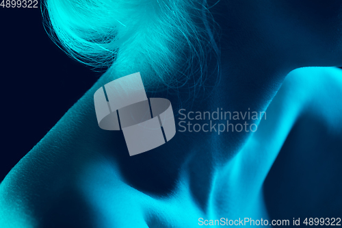 Image of Portrait of beautiful albino girl isolated on dark studio background in neon light